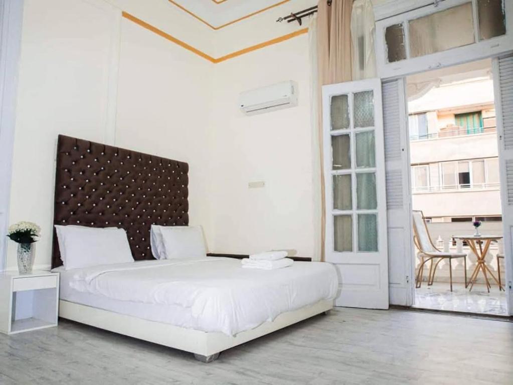 Un dormitorio blanco con una cama grande y una mesa. en New court, en El Cairo