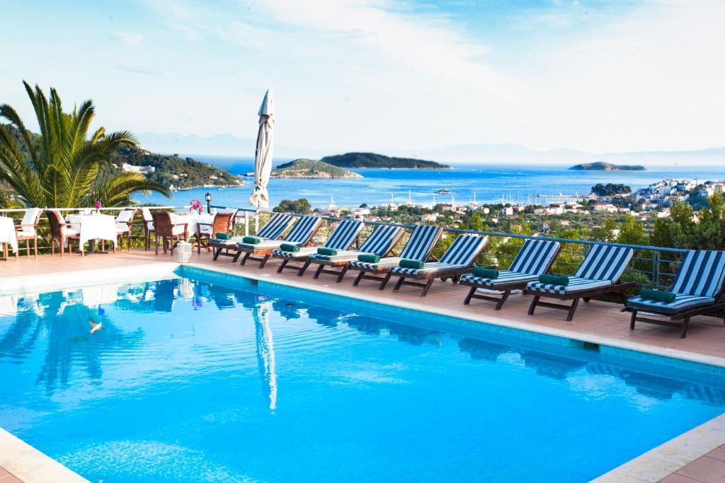 a pool with chairs and a view of the ocean at Vigles Sea View, Philian Hotels and Resorts in Skiathos