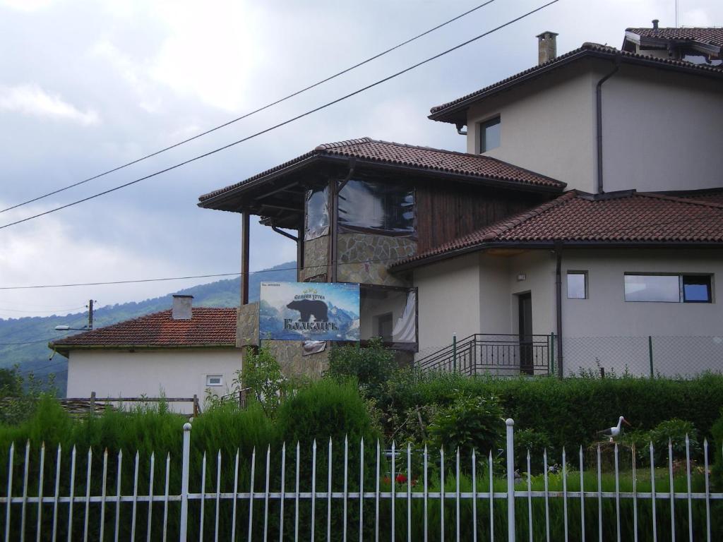 una casa con una torre de reloj delante de ella en Family Hotel Balkana, en Apriltsi