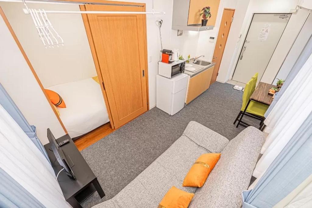 a small room with a couch and a kitchen at Akihabara Skytree Premium Apartment 501 in Tokyo