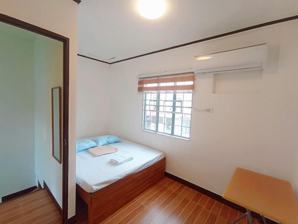 een kleine slaapkamer met een bed en een raam bij JeSa's Serenity Sanctuary in Dasmariñas