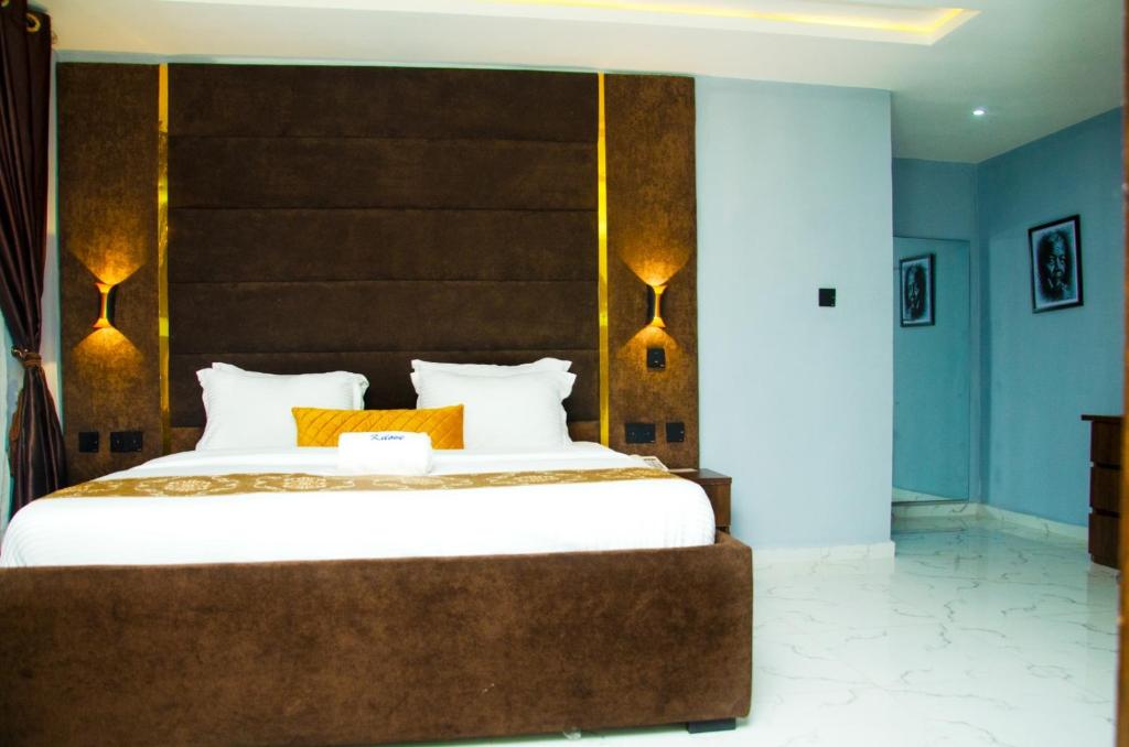 a bedroom with a large white bed with orange pillows at El-Nido Hotel by Kdove in Omole