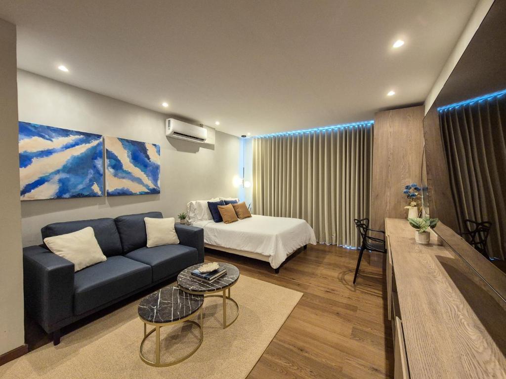 a living room with a couch and a bed at Moderna suite con balcón a pasos de la playa in Cartagena de Indias