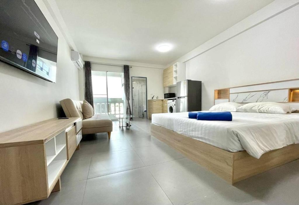 a large bedroom with a large bed and a chair at 9 Karat Condo by PSR in Pattaya Central