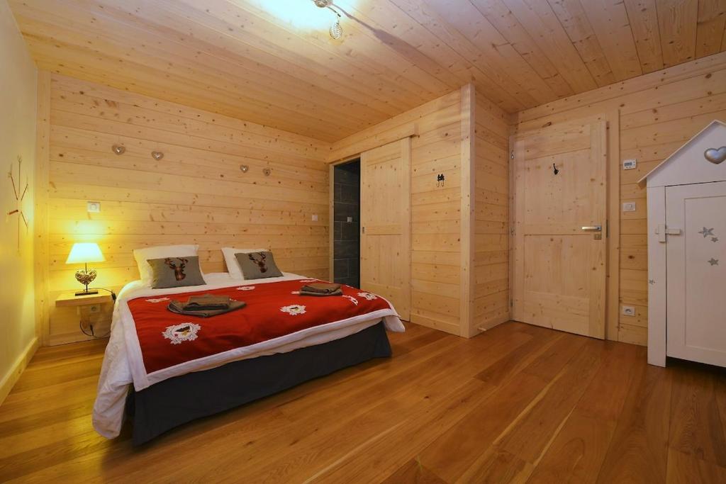 a bedroom with a bed in a wooden room at TETRAS Chalet de prestige, 12 personnes , Pieds des pistes in Vars
