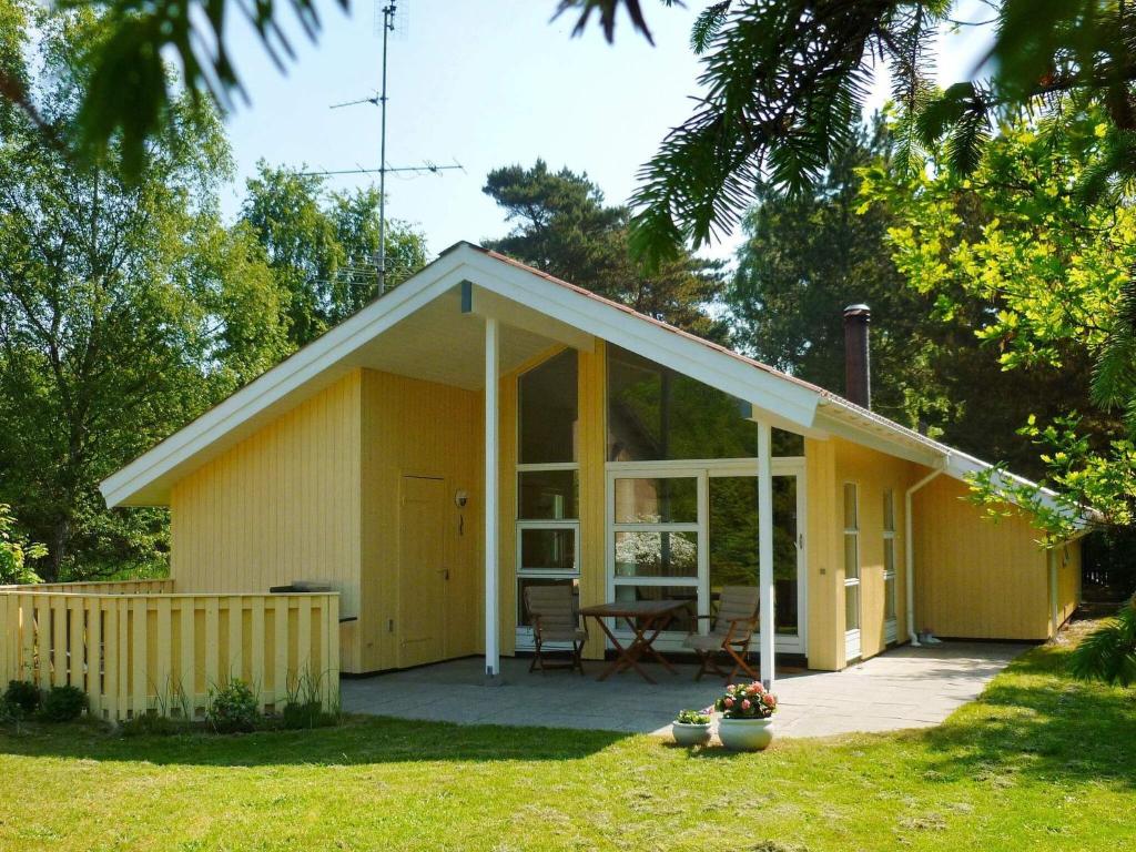 a small yellow house with a table in a yard at Luxury Spa Retreat in Marielyst - By Traum Ferienwohnungen in Marielyst