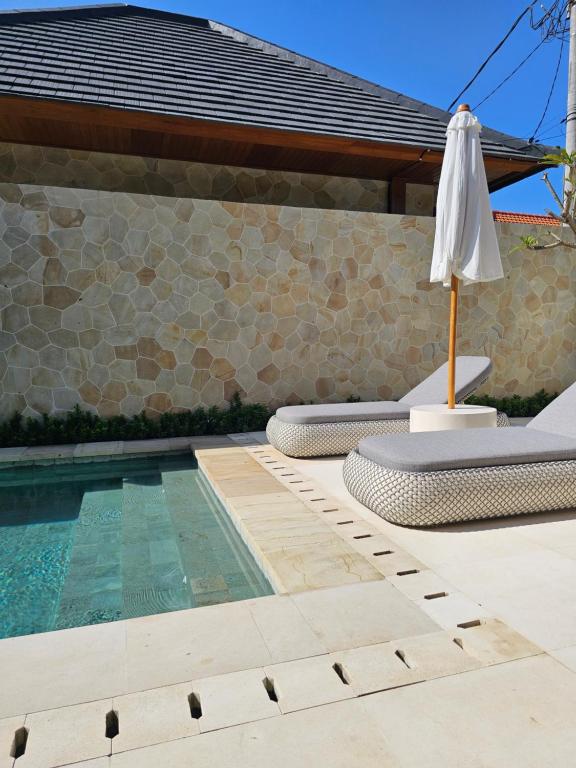 a swimming pool with an umbrella and a swimming pool at Villa Sucasas, Luxury Pool Villa Nusa Dua, Bali in Nusa Dua