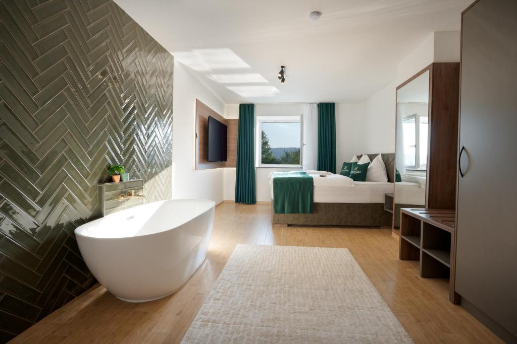 a bathroom with a tub and a bedroom with a bed at Mattiqo Hotel - Modern & Zentral & Free Parking & 24h Self Check-In in Mattighofen