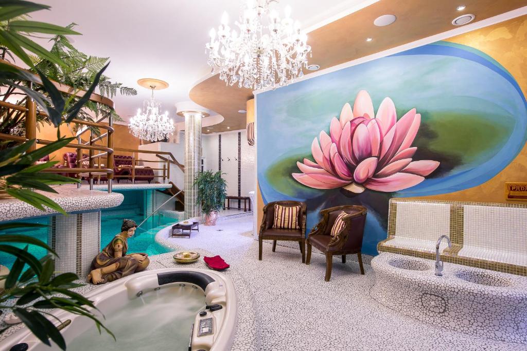 a bathroom with a large painting of a pink flower on the wall at Golden Royal Boutique Hotel & Spa in Košice