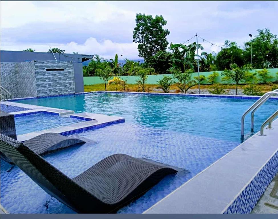 a swimming pool with lounge chairs in a resort at Wilson Hills Travelers Suites in San Juan
