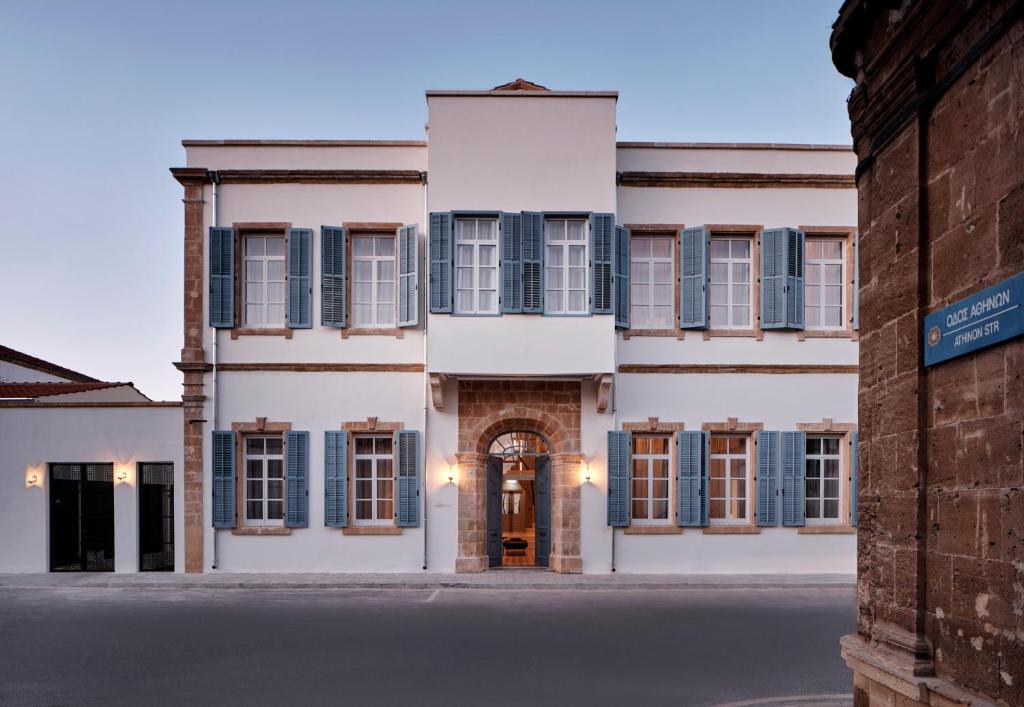 a large white building with blue shuttered windows at Amyth of Nicosia in Nicosia