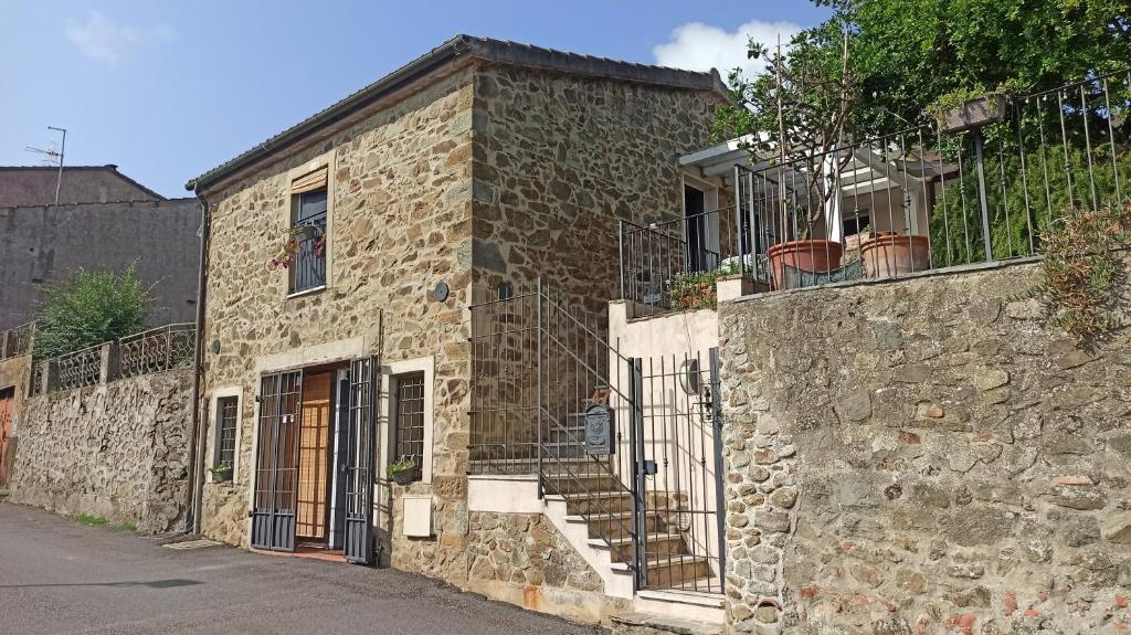 - un bâtiment en pierre avec des escaliers sur son côté dans l'établissement M G VETULONIA, à Vetulonia