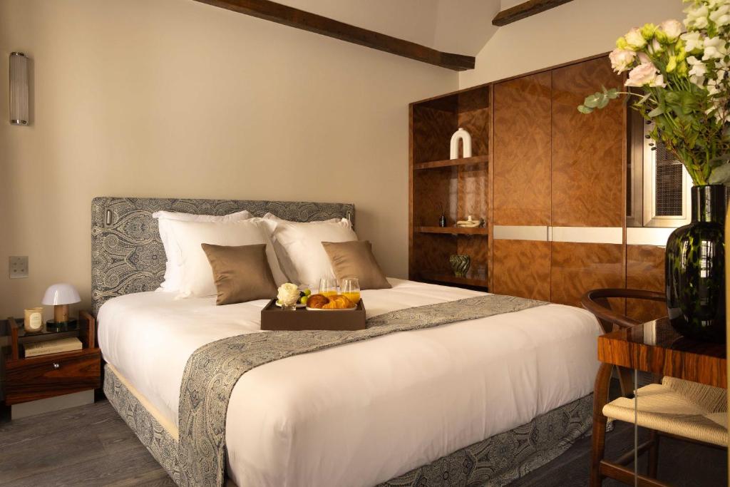 a bedroom with a bed with a tray of fruit on it at Hotel Palais Bourbon in Paris