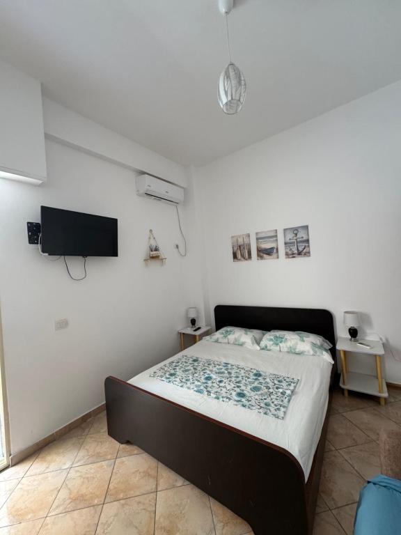 a bedroom with a bed and a flat screen tv at Mira Orikum in Orikum