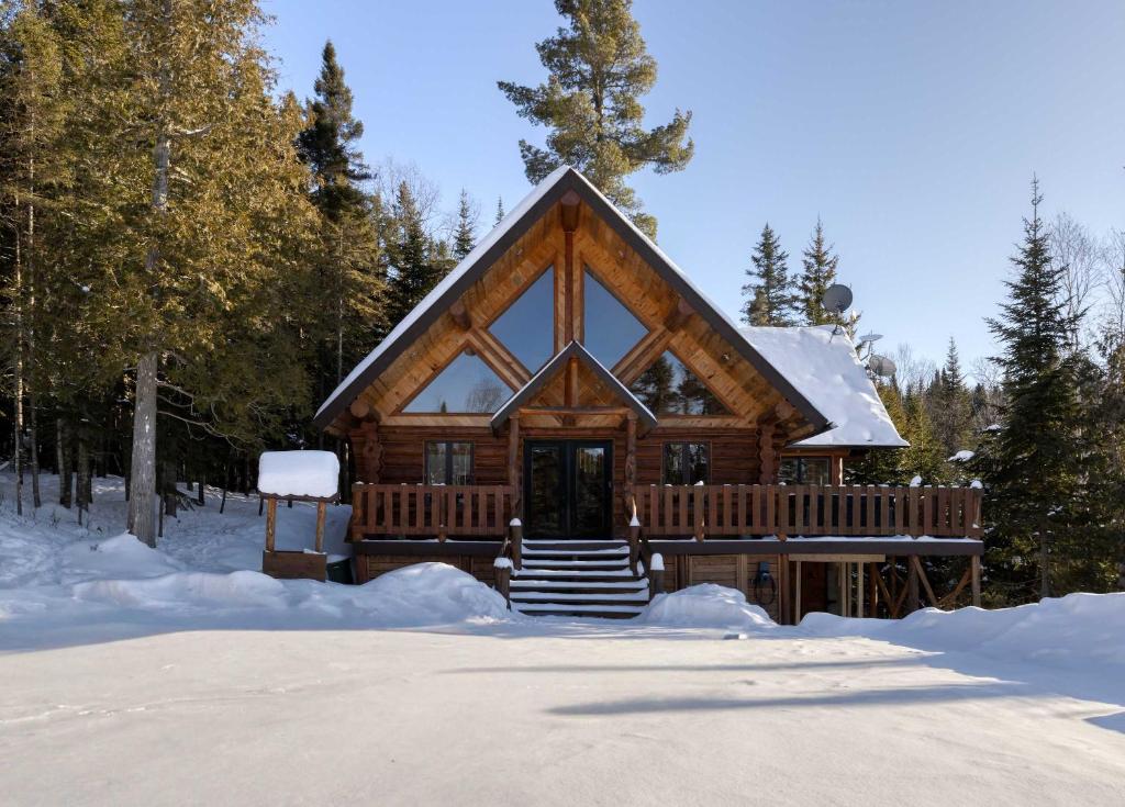 a log cabin in the snow with snow at Spa and Great Comfort - Le Bo Bois Rond in Saint-Michel-des-Saints