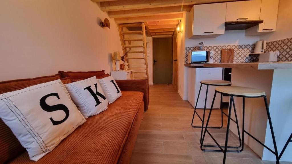 ein Wohnzimmer mit einer Couch und zwei Barhockern in der Unterkunft Cocon au cœur des Montagnes in Puyvalador