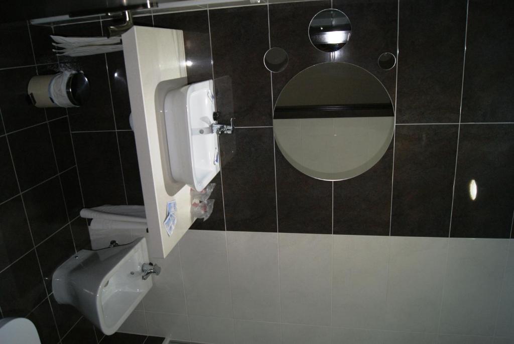 a bathroom with a mirror and a toilet at Hotel Doña Luisa in San Luis de Sabinillas