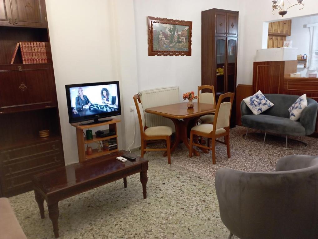 a living room with a table and a tv at Sweet Home Lefkas in Lefkada Town