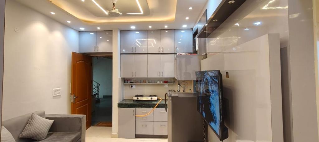 Una cocina con gabinetes blancos y encimera. en Paradise, en Haridwar