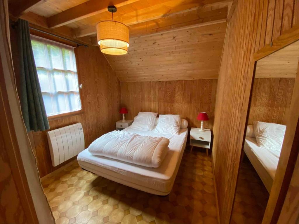 une chambre avec un lit dans une pièce en bois dans l'établissement Chalet 6 personnes Besse et Saint Anastaise, à Besse-et-Saint-Anastaise