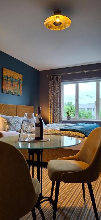 a bedroom with a bed and a table with a bottle of wine at Stoneywood Haven, Galway in Clarinbridge