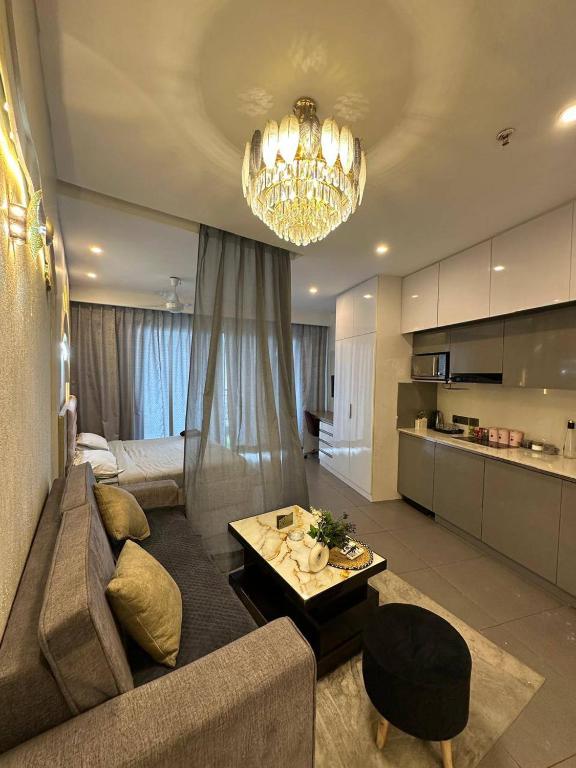 a living room with a couch and a chandelier at Supernova sky and river view heaven in Noida