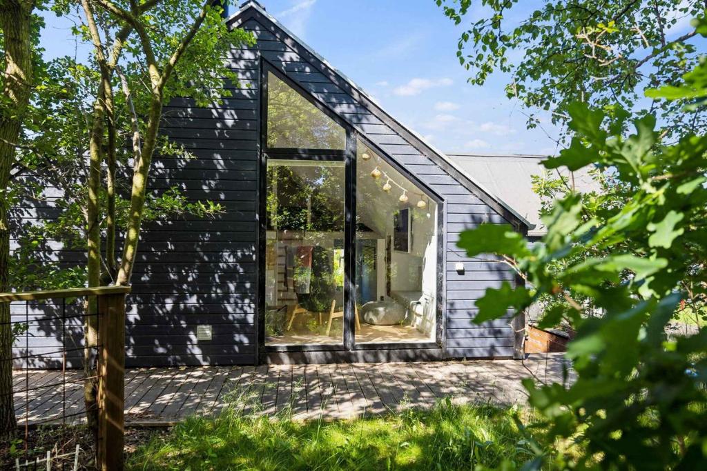 una casa negra con una gran ventana de cristal en Unique Holiday Home Near Houhals, en Hals