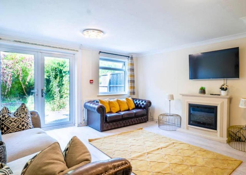 a living room with a couch and a fireplace at House Sleeps 5 - WiFi & Tv in Luton