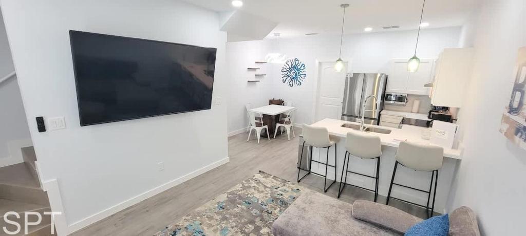 Una sala de estar con un televisor grande y una cocina. en Villas de Laguna 2, en South Padre Island