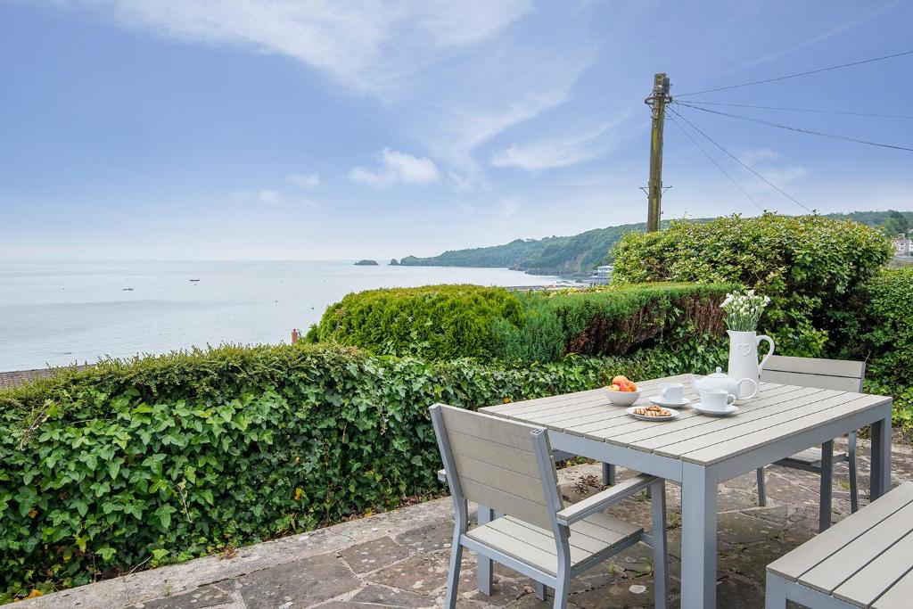 a table and chairs with a view of the water at The Rath in Saundersfoot