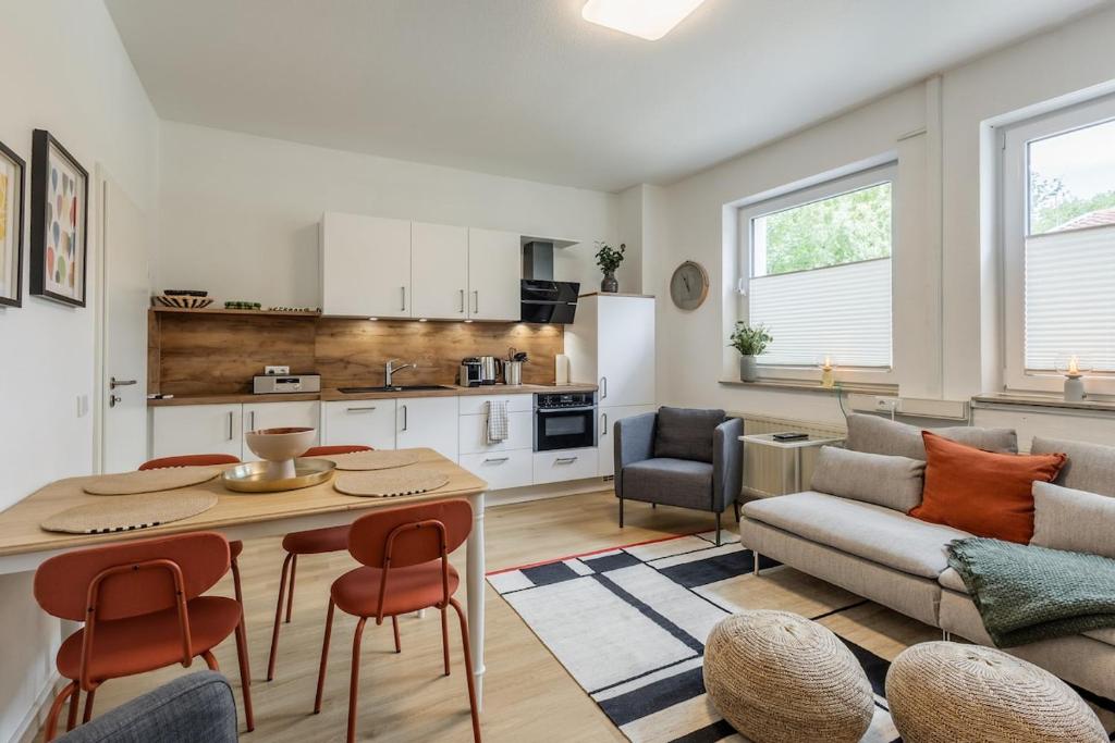 a kitchen and living room with a table and chairs at Ems-Suite 01 I City I WiFi I 4 Personen I Klimaanlage in Warendorf