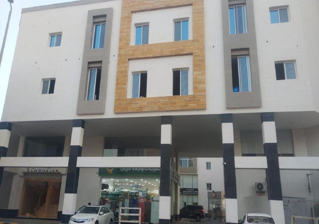 a large white building with cars parked in front of it at شقق ماجد حي الريان in Jeddah