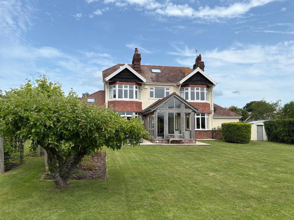 a large house with a green lawn in front of it at Coastal Family Escape with Castle Views in Deganwy