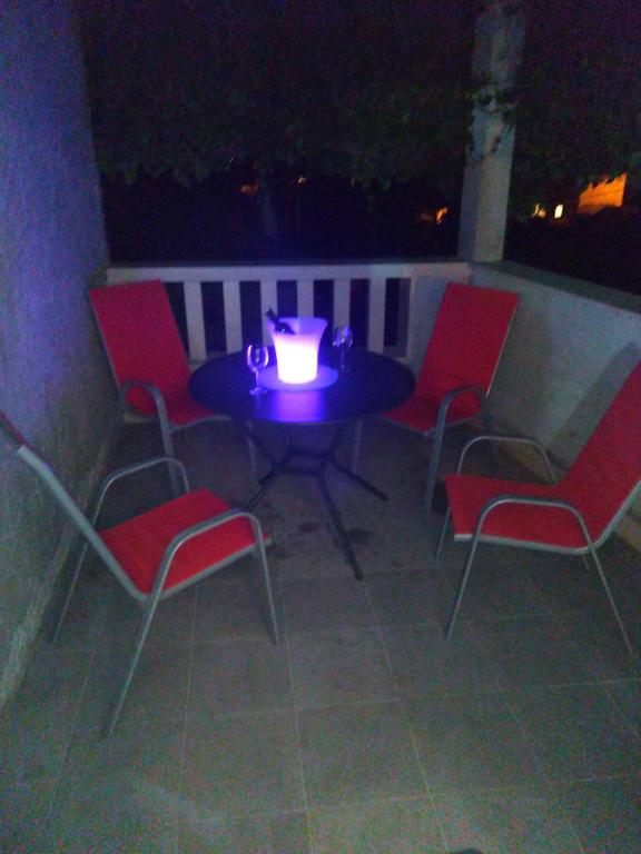 a table and chairs with a candle on a patio at Apartment Tara in Sumartin