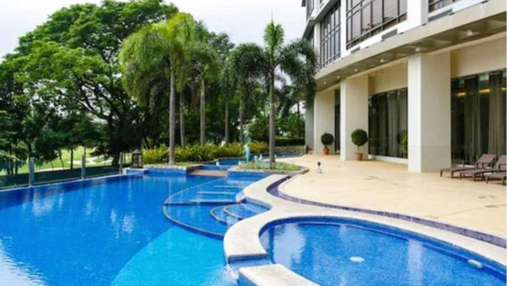 a swimming pool in front of a building at Executive Suites Bellagio Golf View Residences in Manila