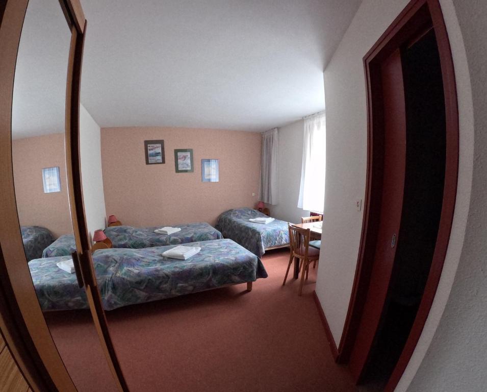 a hotel room with two beds and a mirror at Au Pont de la Ginéze in Barjac