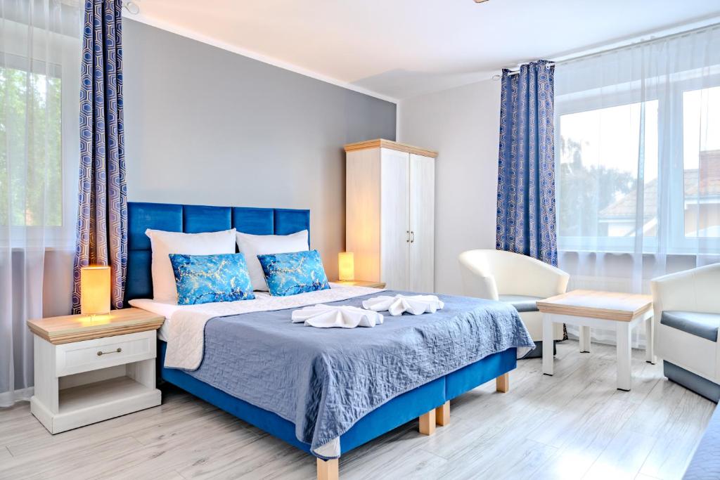 a bedroom with a blue bed with a blue bedspread at Pablo in Niechorze