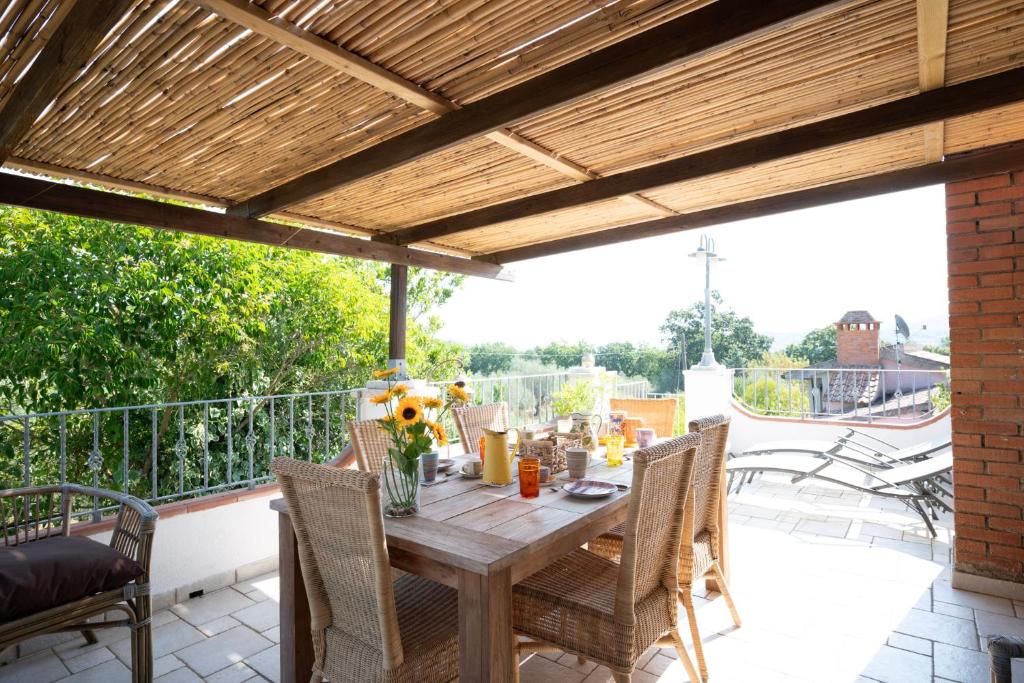 a patio with a wooden table and chairs on a balcony at La Casa dei Quadri in Ravi