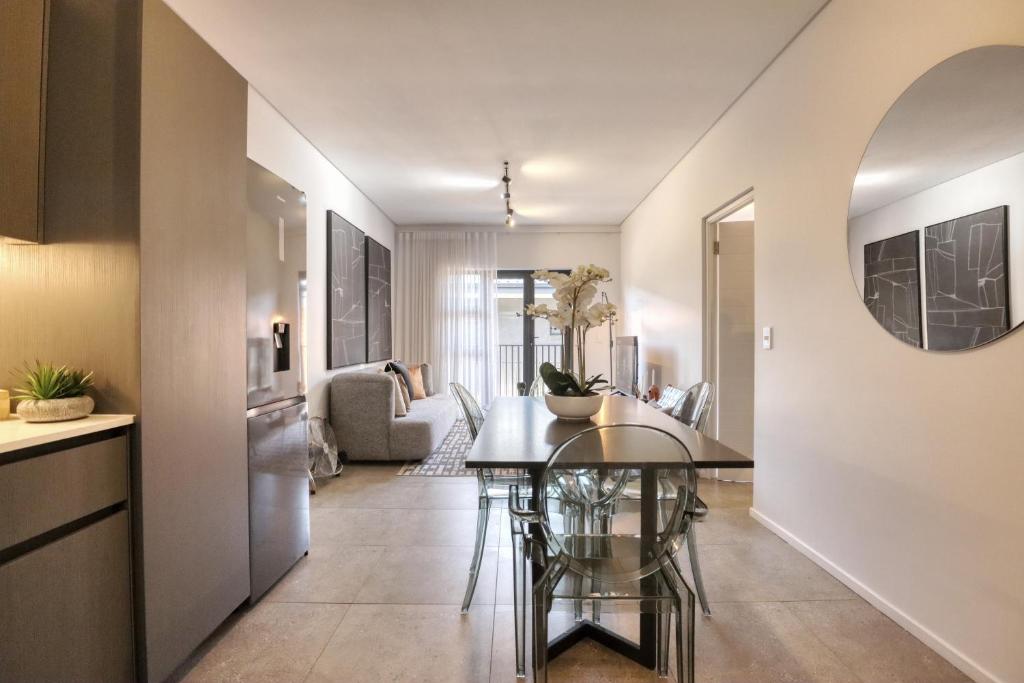 约翰内斯堡Modern Luxury 1BR in Hyde Park的一间厨房和客厅,客厅内配有桌子