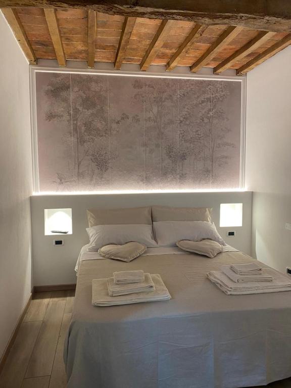 a bedroom with a large bed with two towels on it at Frattina1860 in Montisi