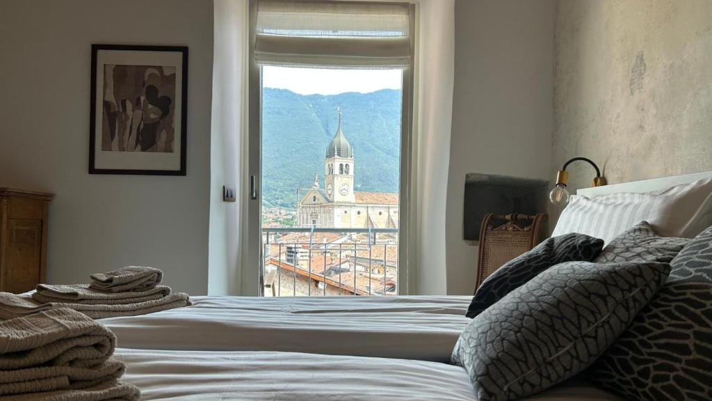 una camera con un letto e una finestra con una torre dell'orologio di Casa Renzo ad Arco