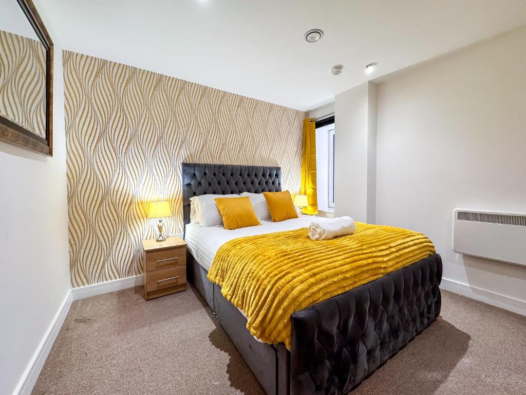 a bedroom with a large bed with a yellow blanket at Stylish Loft Apartment Weekend Holiday Stay in Central Station