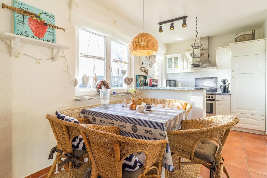 a kitchen and dining room with a table and chairs at Inselhaus Whg 03 in Stubbenfelde