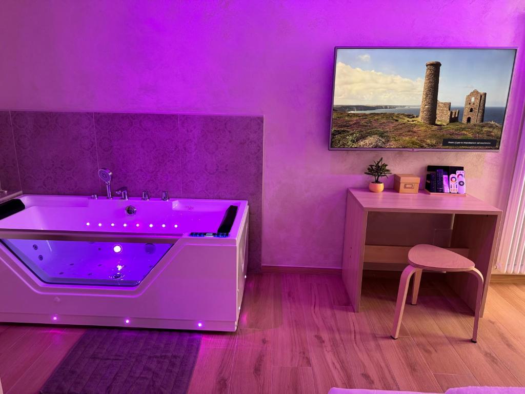 a purple bathroom with a purple tub and a table at Jacuzzi Romantic Suite - SuiteHeart Torino - Inalpi, Olimpico, Centre in Turin