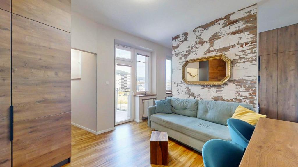 a living room with a blue couch and a brick wall at The Hideout in Žilina
