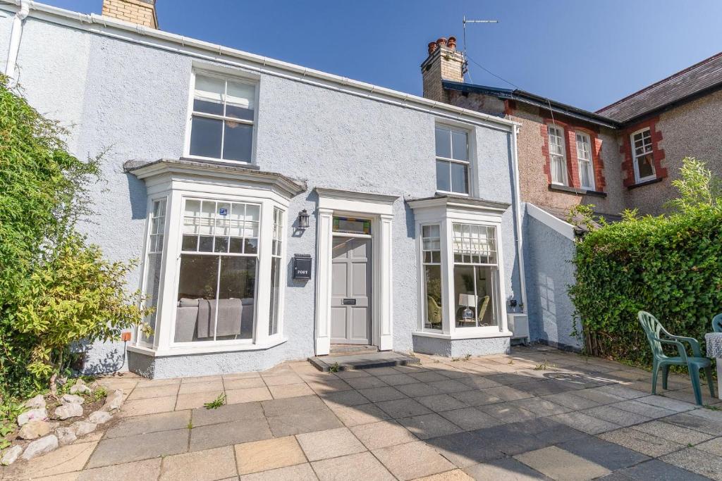 a white house with white windows and a patio at Coastal Home in Mumbles with Garden & WiFi in Swansea