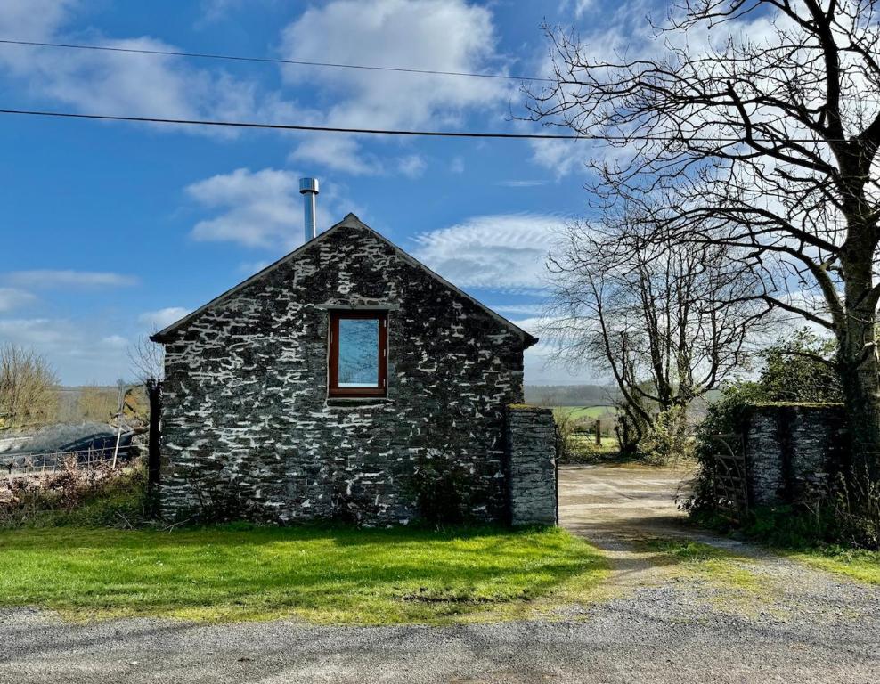 an old stone building with a window in the grass at Barn Retreat with Mountain Views in Athy