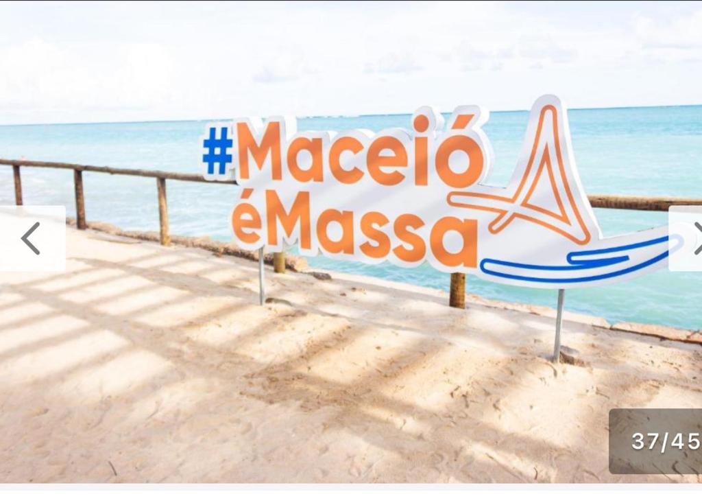 um sinal na praia com o oceano ao fundo em lindo apartamento de frente para à praia de pajuçara em Maceió