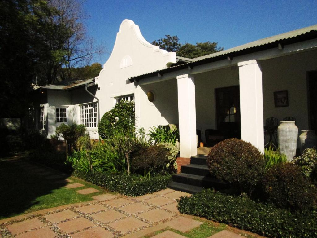 a white house with a staircase in front of it at Brooks Cottage in Pretoria