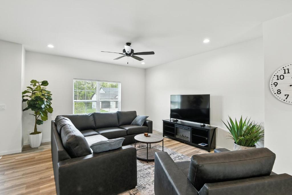 a living room with a couch and a tv at Modern Townhome Retreat in Prime Location townhouse in Coralville